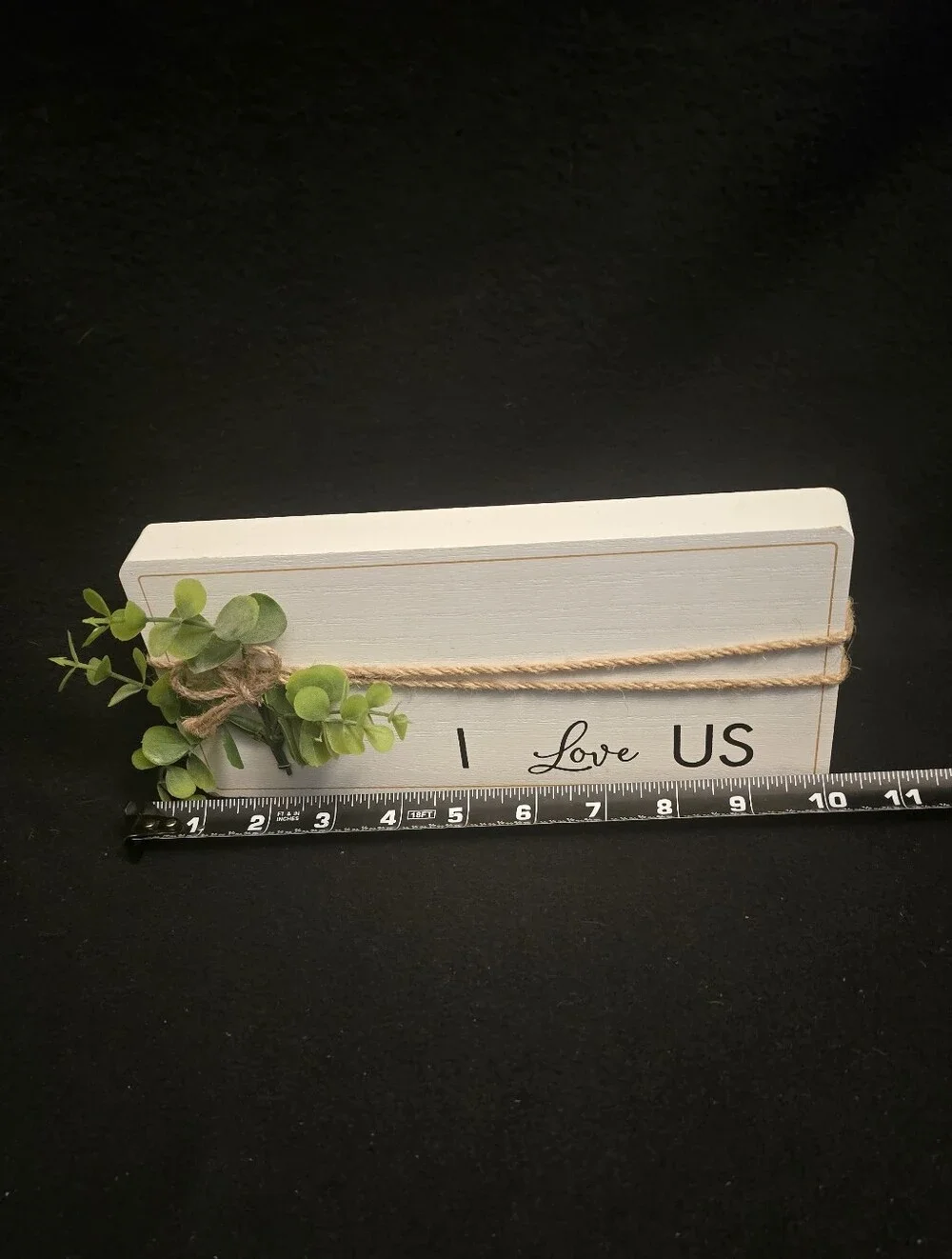White 'I Love Us'  Sign with Green Faux Foliage